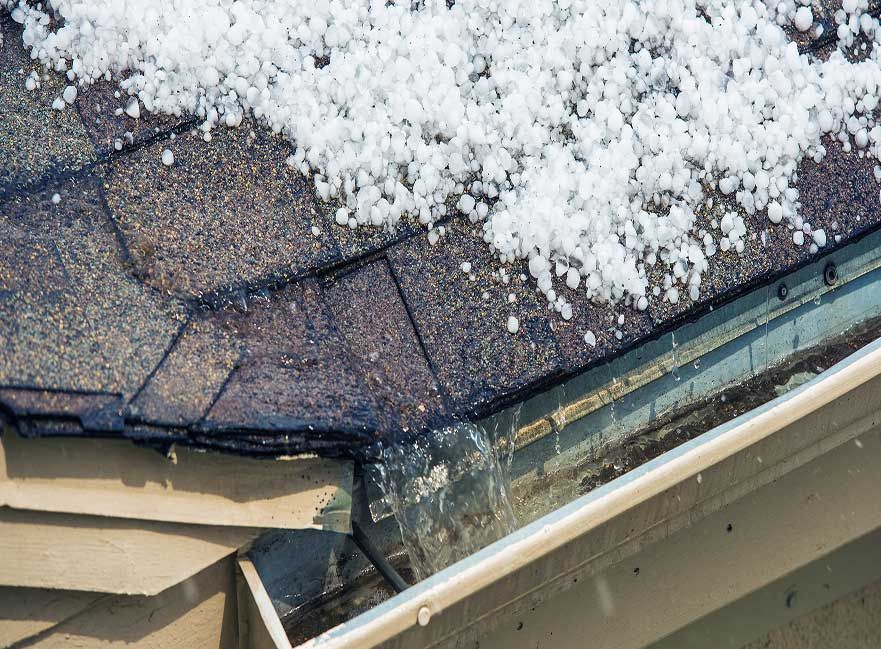 Hailstones piled in a roof gutter after a storm