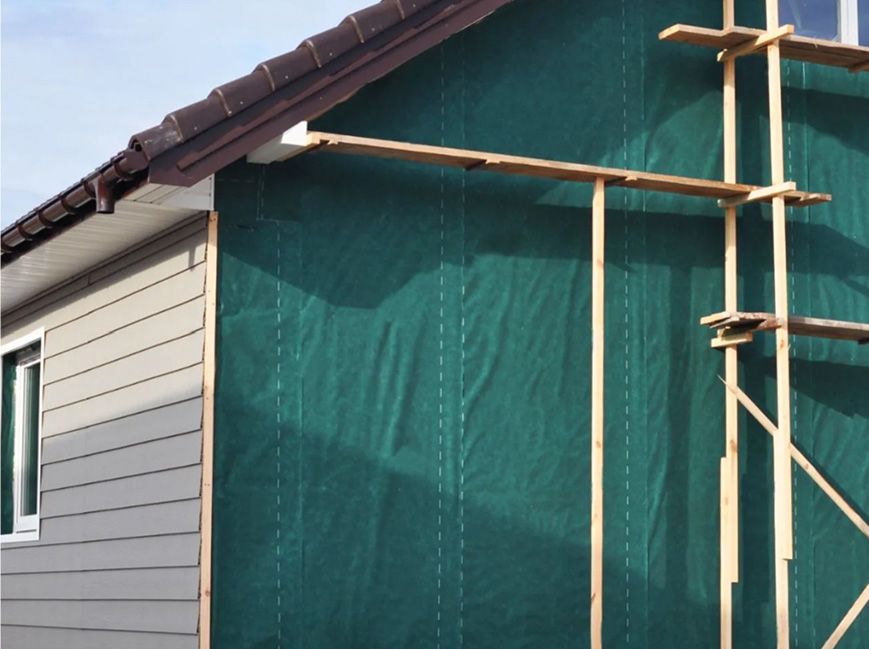 A house mid-construction with siding being installed