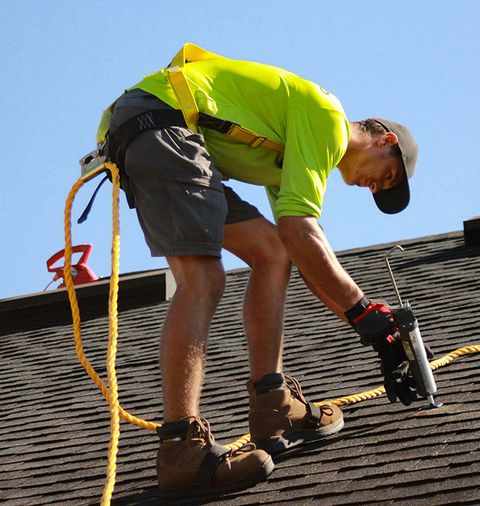 JS Exteriors technician inspecting a roof