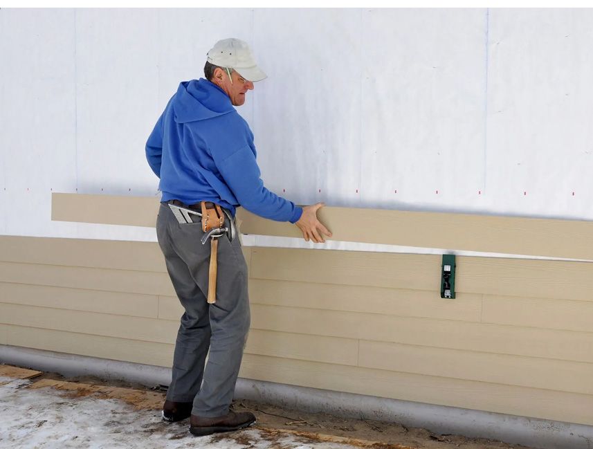 JS Exteriors installer fitting a new siding panel