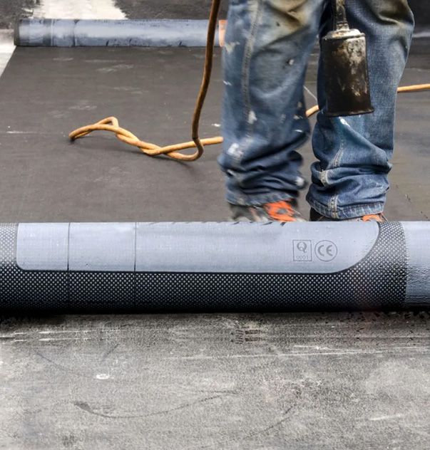 JS Exteriors crew rolling out a commercial roofing membrane